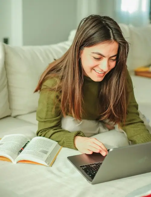 Student with a laptop and book during an online lesson